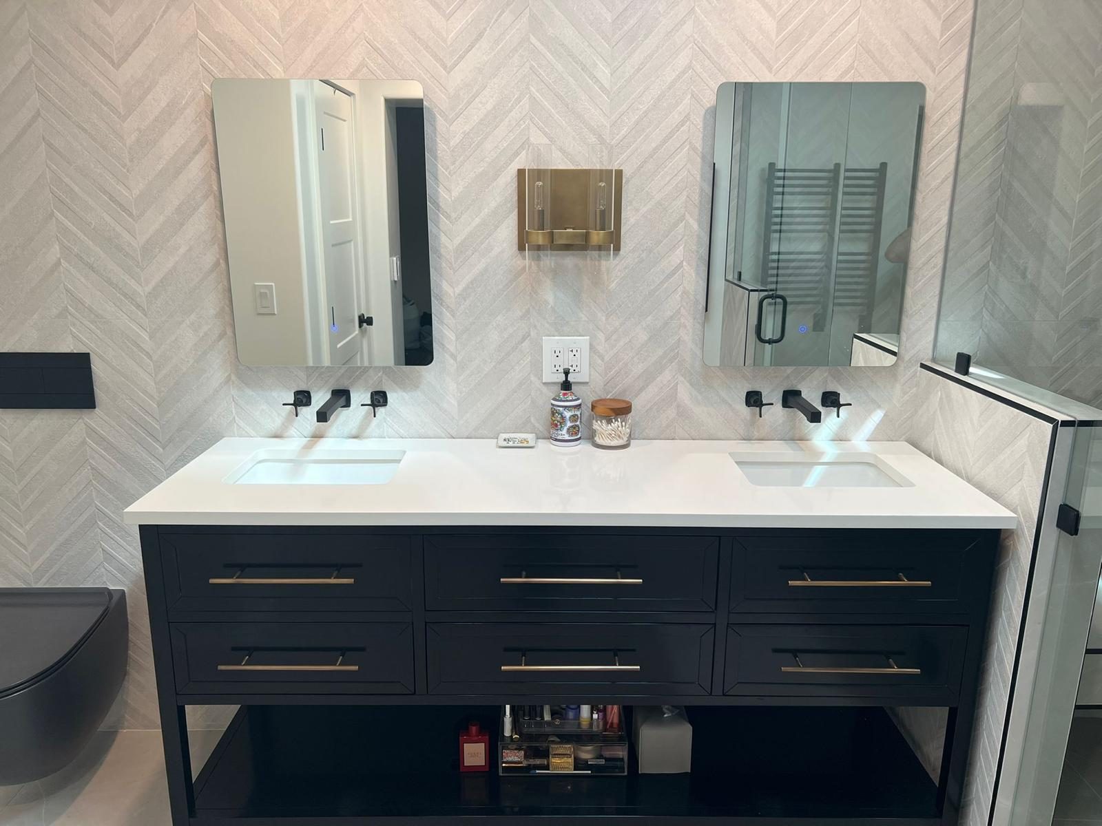 Remodeled Austin bathroom with a double vanity, black cabinets and chevron tile walls