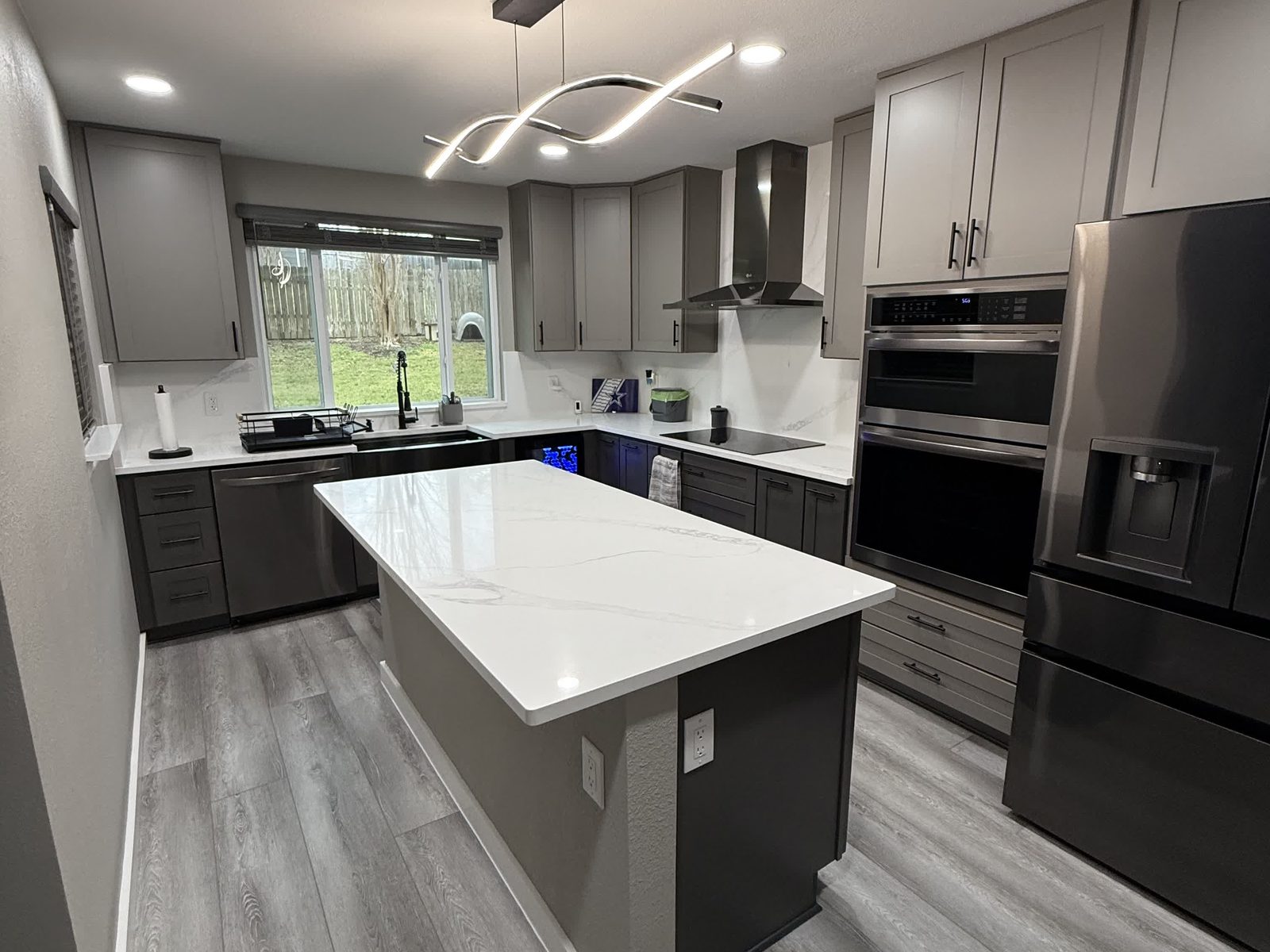 Wide-plank wood-look flooring in a remodeled Austin kitchen with a large island