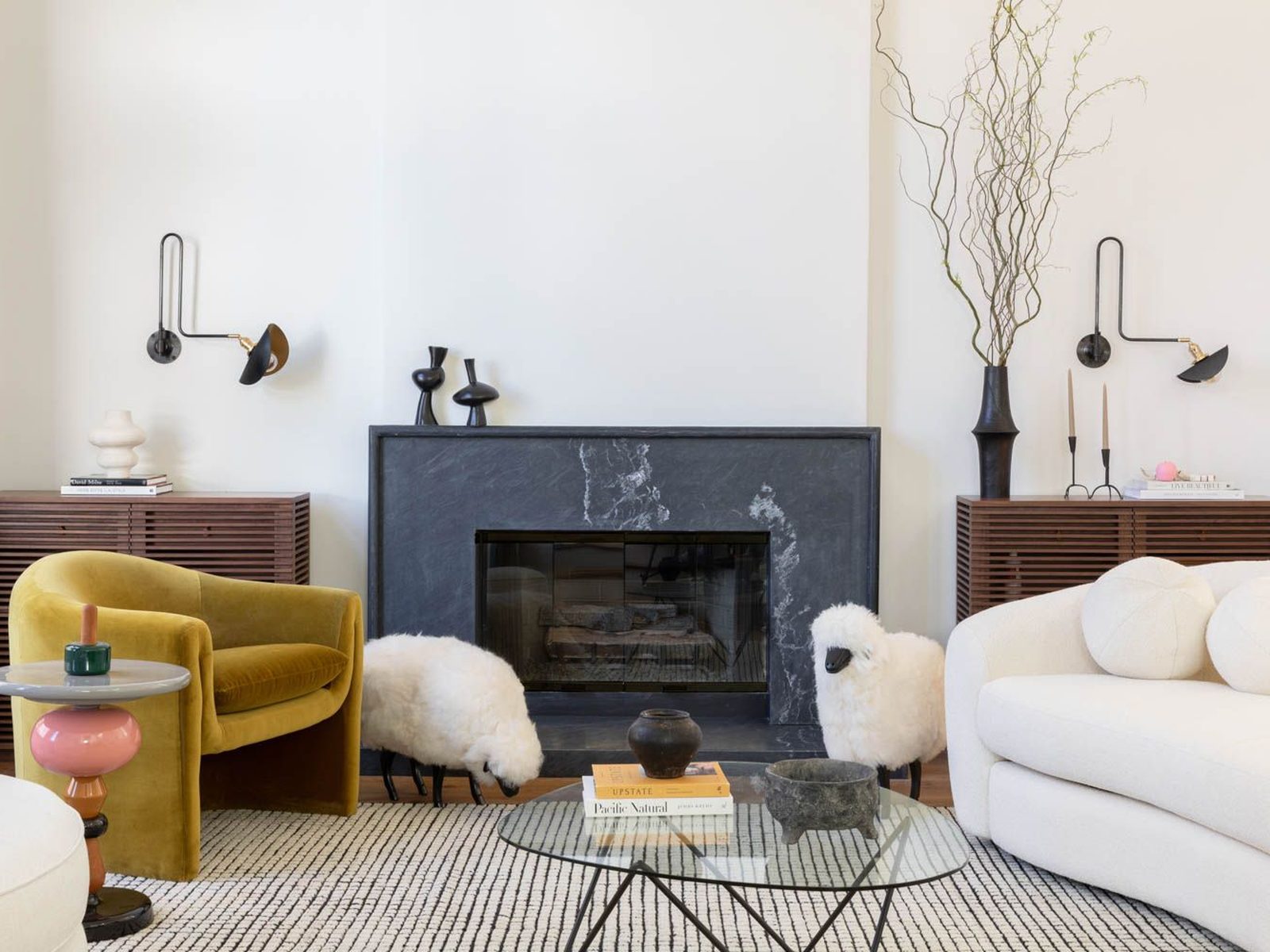 Whole-home remodel living room in Austin with a stone fireplace, curved sofa and armchair